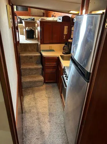 Slide: The Image of 1989 Post 43 Sport Fisherman interior with kitchen, stairs, and wooden cabinetry. - 28