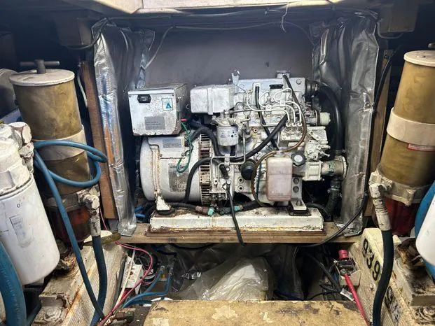 Slide: The Image of Engine room of a 1989 Post 43 Sport Fisherman boat, featuring mechanical components and wiring. - 37