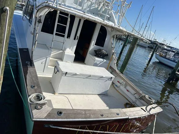 Slide: The Image of 1989 Post 43 Sport Fisherman boat docked at marina, featuring spacious deck and fishing equipment. - 5