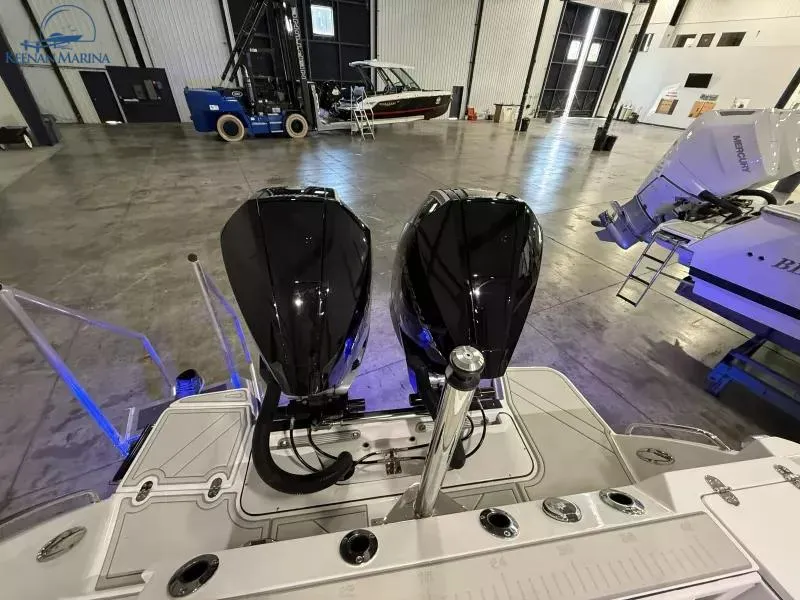 Slide: The Image of 2025 Blackfin 272CC boat with dual engines in a spacious indoor marina. - 14