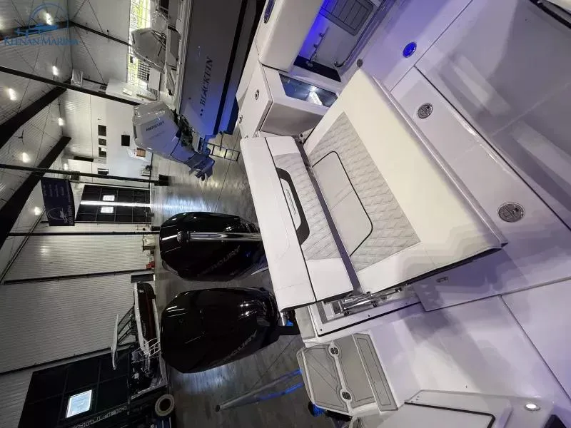 Slide: The Image of 2025 Blackfin 272CC boat interior with modern seating and storage in a showroom. - 4