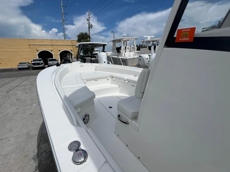 Slide: The Image of 2023 Regulator 26XO boat with white seating, docked under a clear blue sky. - 11