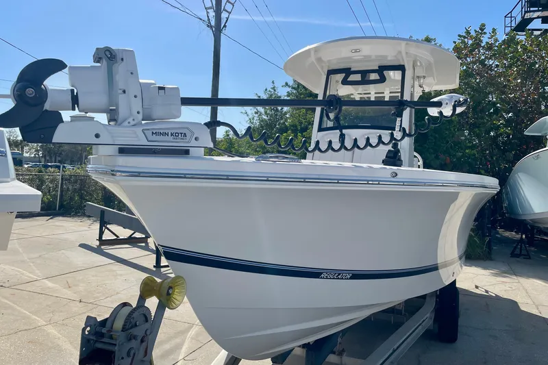 Slide: The Image of 2023 Regulator 26XO boat with Minn Kota trolling motor, displayed outdoors. - 3