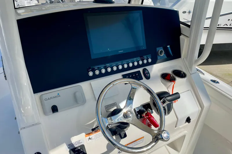 Slide: The Image of 2023 Regulator 26XO boat dashboard with Garmin display and steering wheel. - 7
