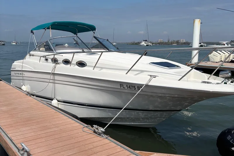 The Image of 2001 Regal Cruiser Commodore boat docked at marina with blue canopy. - 0