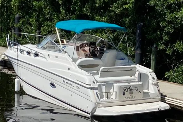 Slide: The Image of 2001 Regal Cruiser Commodore boat docked with blue canopy, labeled "Relax!" in Naples, FL. - 5