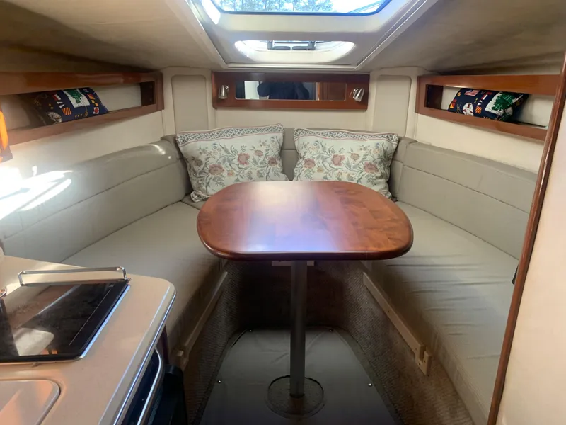 Slide: The Image of 2009 Sea Ray 270 Sundancer cabin with cozy seating and wooden table. - 11
