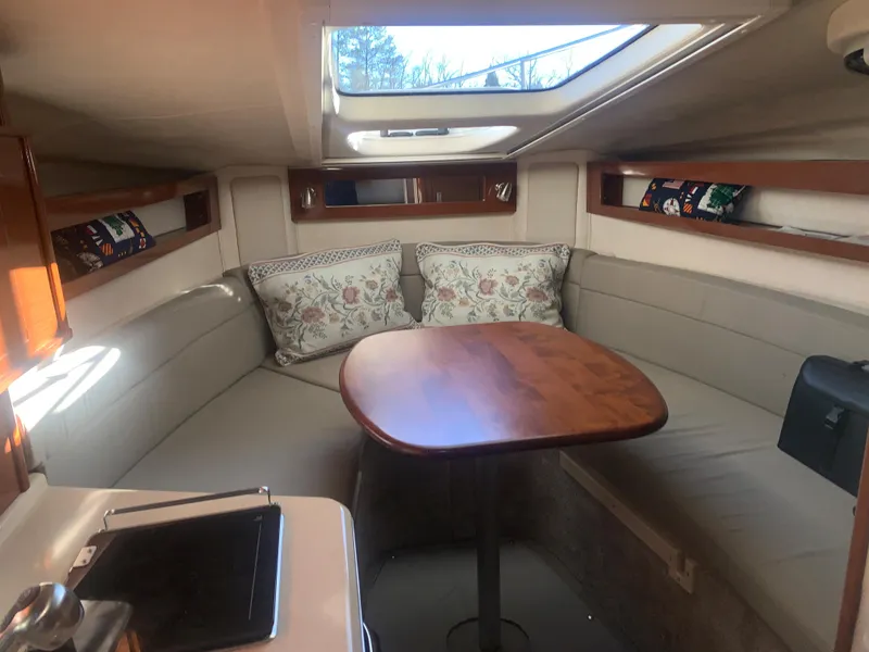 Slide: The Image of Interior of 2009 Sea Ray 270 Sundancer with cozy seating and wooden table. - 12