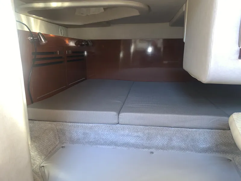 Slide: The Image of 2009 Sea Ray 270 Sundancer cabin interior with cushioned sleeping area. - 13