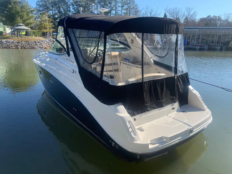 Slide: The Image of 2009 Sea Ray 270 Sundancer boat docked on calm water, featuring a black canopy. - 4