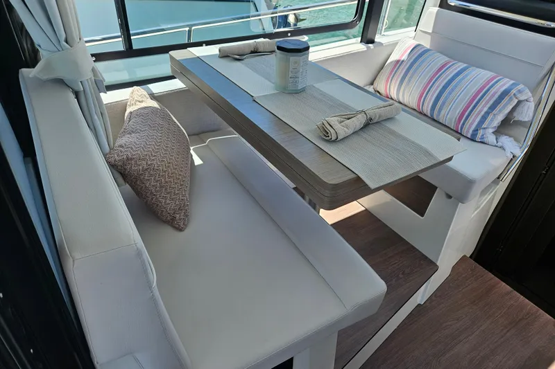 Slide: The Image of Interior of 2026 Jeanneau NC 895 Sport Series 2, featuring a cozy dining area with cushions. - 11