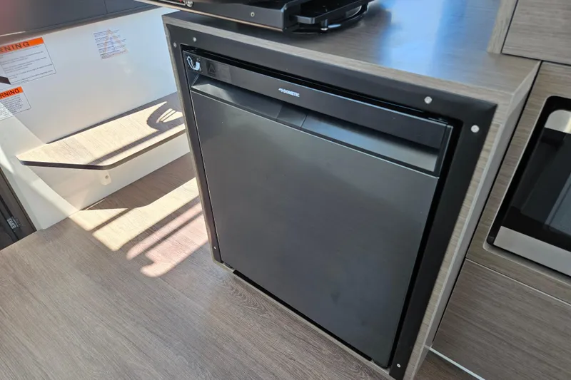 Slide: The Image of Compact refrigerator inside 2026 Jeanneau NC 895 Sport Series 2 boat interior. - 18