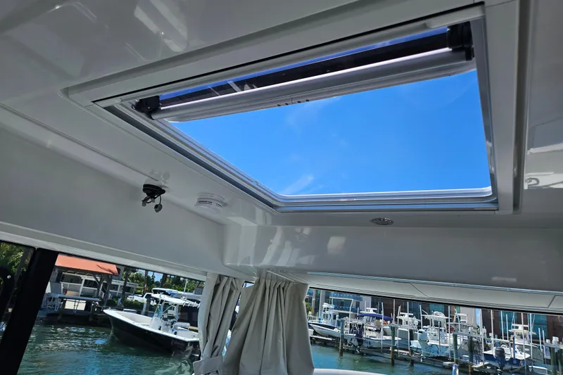 Slide: The Image of Skylight view from 2026 Jeanneau NC 895 Sport Series 2, showcasing marina and blue sky. - 22