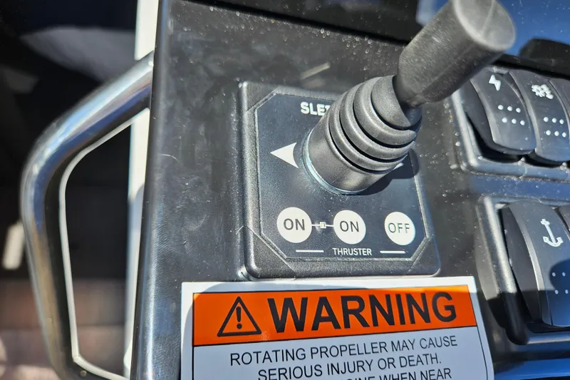 Slide: The Image of Control panel of 2026 Jeanneau NC 895 Sport Series 2 with thruster joystick and warning label. - 24