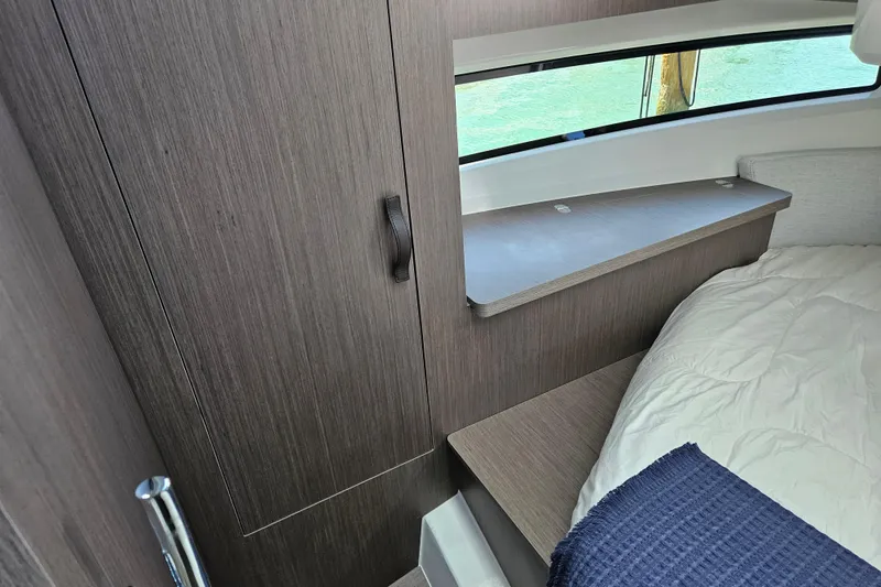 Slide: The Image of Interior cabin of 2026 Jeanneau NC 895 Sport Series 2, featuring wood paneling and bedding. - 27