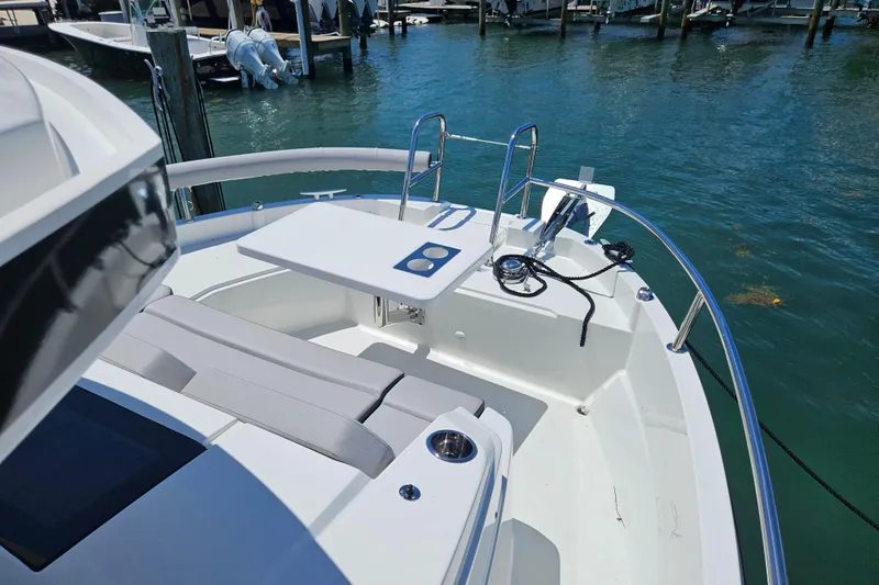 Slide: The Image of 2026 Jeanneau NC 895 Sport Series 2 boat deck with seating and table, docked at marina. - 34