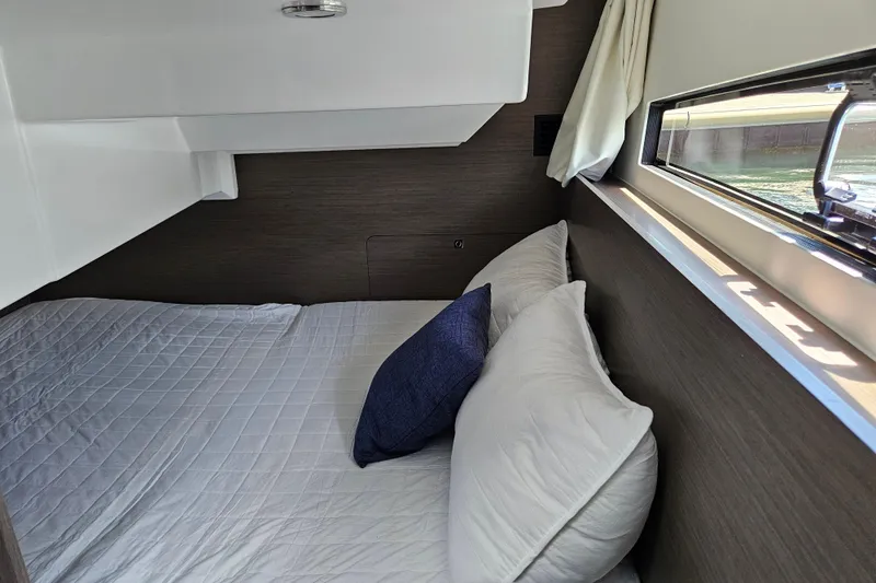 Slide: The Image of Cozy cabin interior of 2026 Jeanneau NC 895 Sport Series 2 with bed and window view. - 44