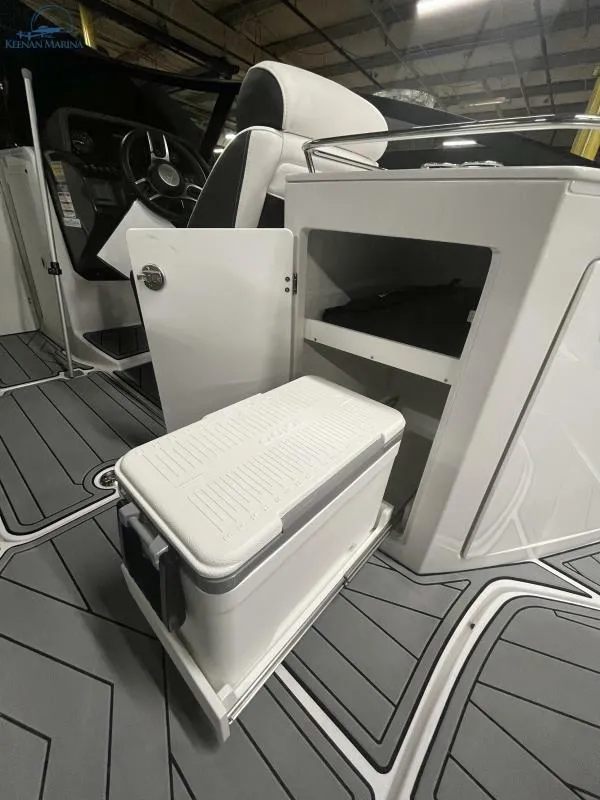Slide: The Image of 2024 Monterey M6 boat interior with open storage and cooler on gray flooring. - 12