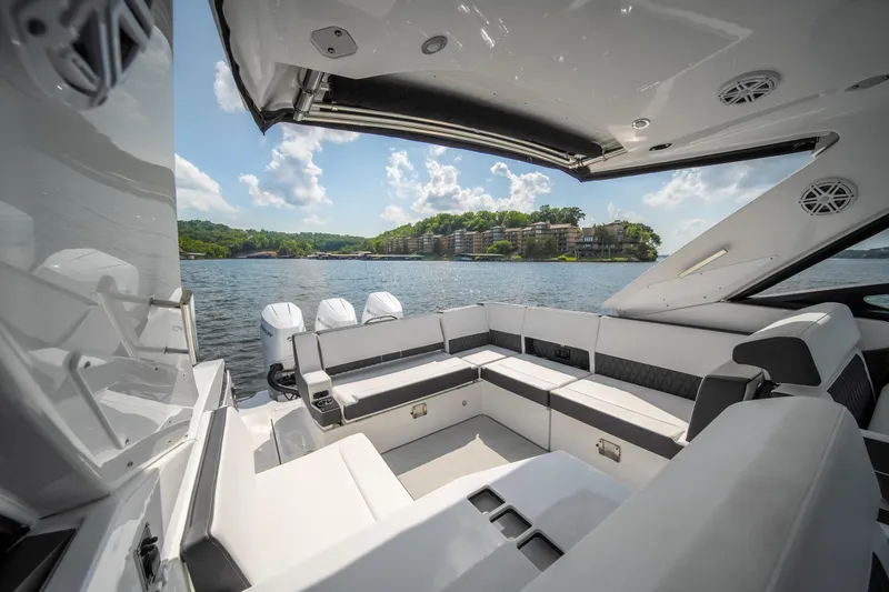 Slide: The Image of 2024 Monterey 385SS boat interior with luxurious seating, overlooking a scenic waterfront view. - 15