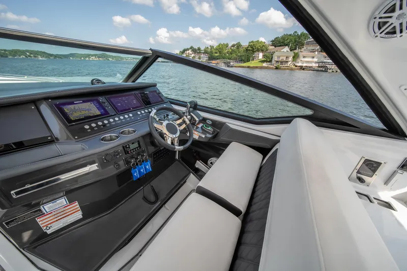 Slide: The Image of 2024 Monterey 385SS boat cockpit with modern controls and scenic lake view. - 17