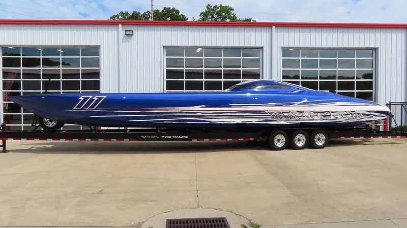 The Image of 2007 Mystic Powerboats 50' in blue, parked on a trailer outside a garage. - 0