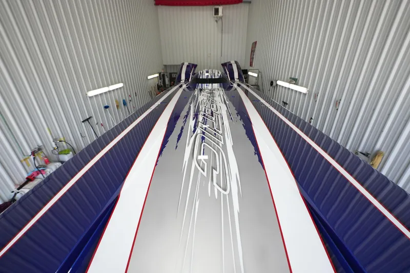 Slide: The Image of 2007 Mystic Powerboats 50' with sleek design and vibrant graphics in a storage facility. - 16