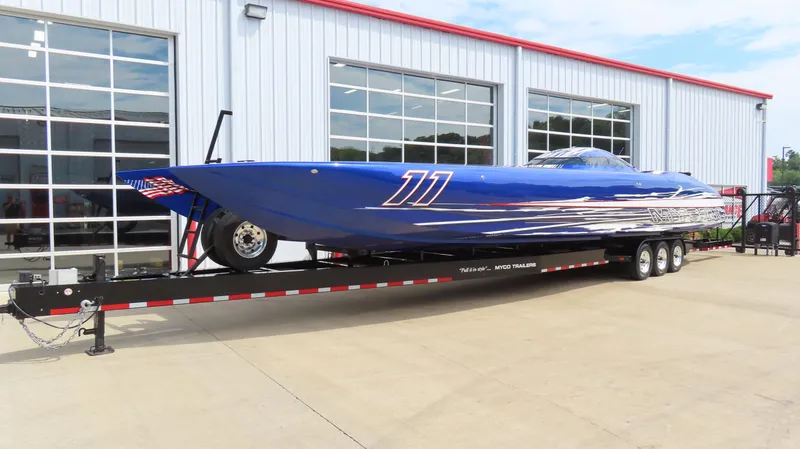 Slide: The Image of 2007 Mystic Powerboats 50' model, blue, on trailer outside a garage. - 2
