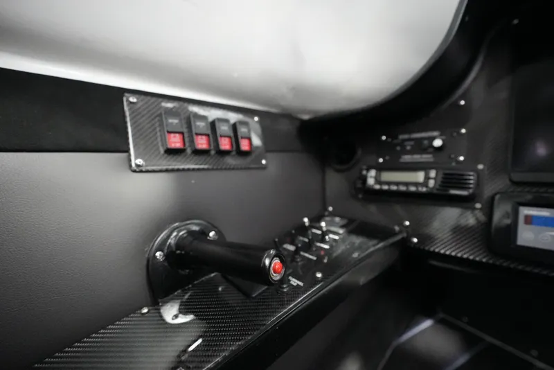 Slide: The Image of Control panel of a 2007 Mystic Powerboats 50' with carbon fiber finish and switches. - 20