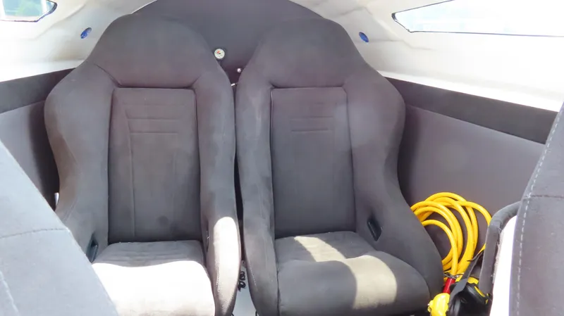 Slide: The Image of Interior of a 2007 Mystic Powerboats 50' with two black seats and coiled yellow rope. - 33