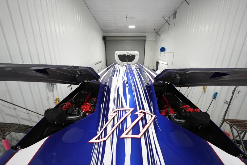 Slide: The Image of 2007 Mystic Powerboats 50' with blue and white racing stripes in a storage facility. - 41