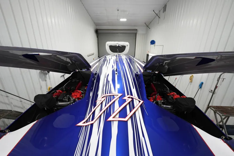 Slide: The Image of 2007 Mystic Powerboats 50' with blue and white racing stripes in a garage. - 42