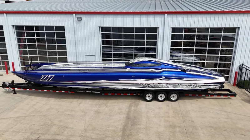 Slide: The Image of 2007 Mystic Powerboats 50' model, blue and silver, on a trailer outside a garage. - 6