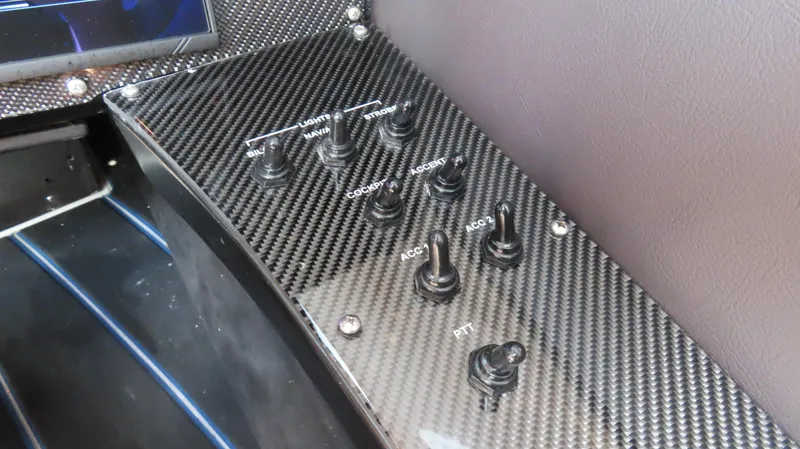 Slide: The Image of Carbon fiber control panel with switches on a 2007 Mystic Powerboats 50' model. - 9