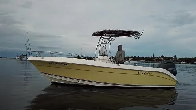 Slide: The Image of 2005 Cobia 214 CC boat on calm water, overcast sky in background. - 11