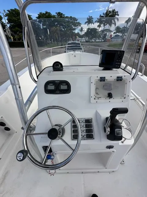 Slide: The Image of 2005 Cobia 214 CC boat console with steering wheel and navigation equipment. - 12