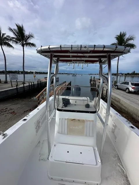 Slide: The Image of 2005 Cobia 214 CC boat docked near palm trees and waterfront. - 14