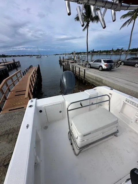 Slide: The Image of 2005 Cobia 214 CC boat docked by a scenic waterfront with palm trees. - 15