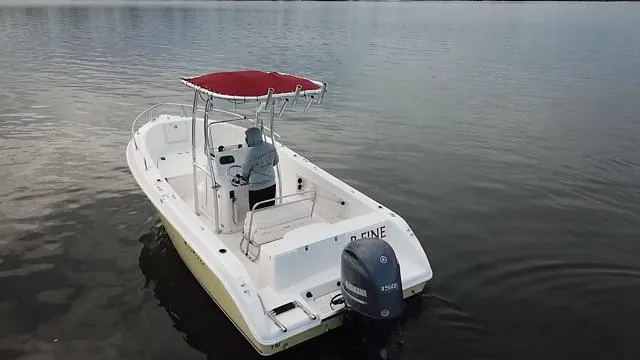 Slide: The Image of 2005 Cobia 214 CC boat with red canopy on calm water. - 3