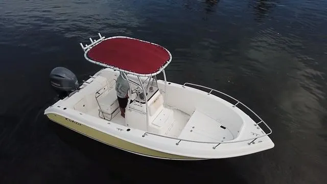 Slide: The Image of 2005 Cobia 214 CC boat with red canopy on calm water. - 5