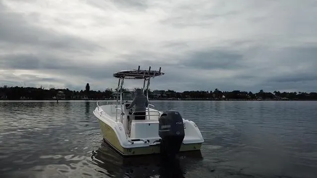 Slide: The Image of 2005 Cobia 214 CC boat on calm water under cloudy sky. - 7