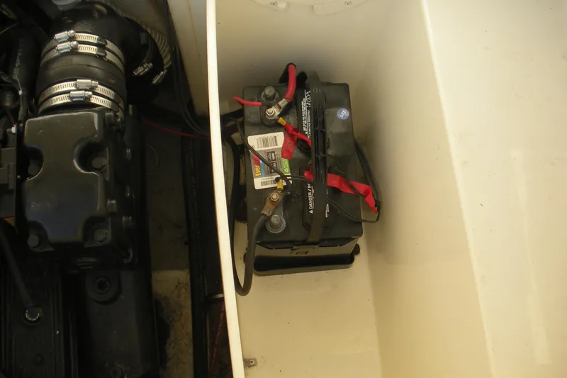 Slide: The Image of Battery compartment of 1999 Rinker 232 Captiva Cuddy boat, showing engine components. - 21
