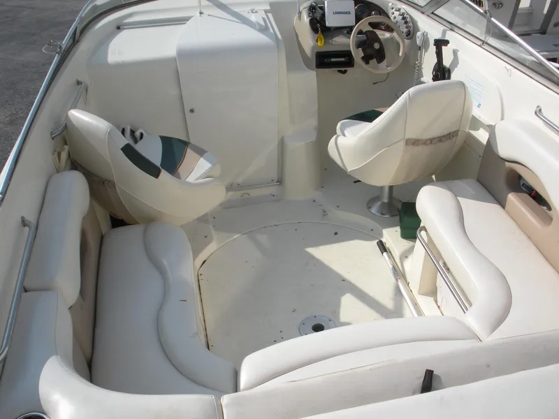 Slide: The Image of 1999 Rinker 232 Captiva Cuddy boat on trailer, parked outside a building. - 5