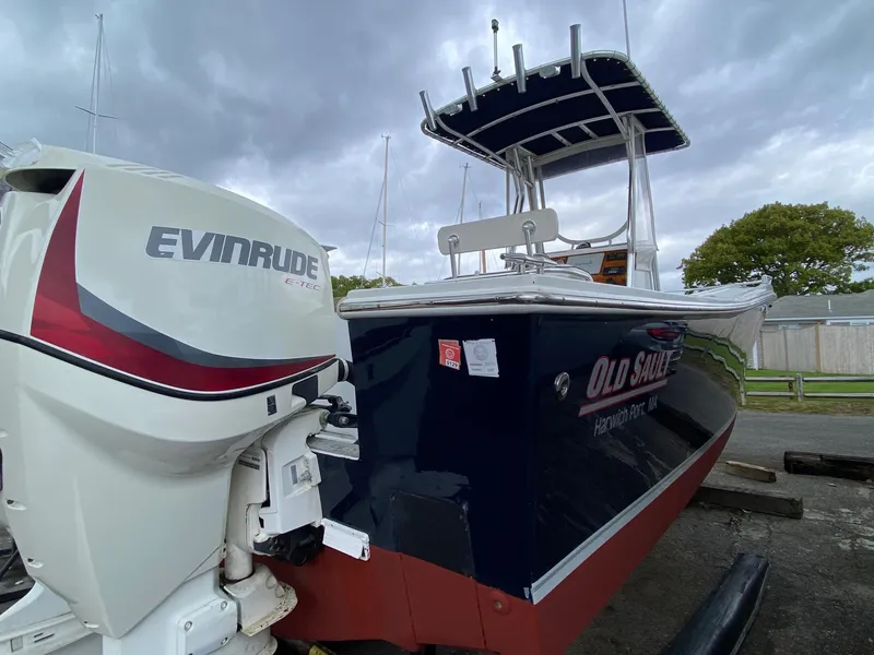 Slide: The Image of 1991 Mako 241 boat with Evinrude engine, docked under cloudy skies. - 10