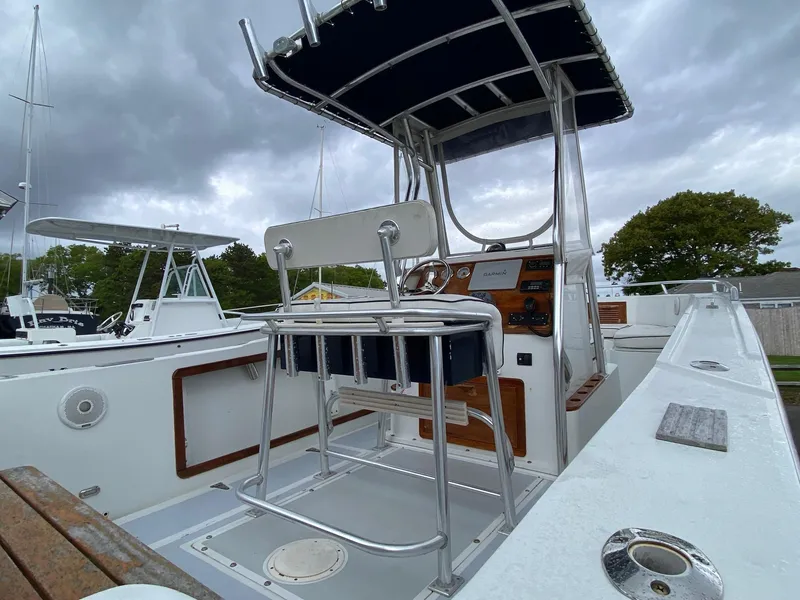 Slide: The Image of 1991 Mako 241 boat interior with console and seating under cloudy sky. - 12
