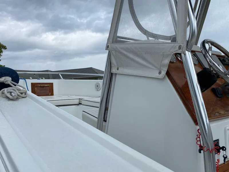 Slide: The Image of 1991 Mako 241 boat interior with steering wheel, under cloudy sky. - 14