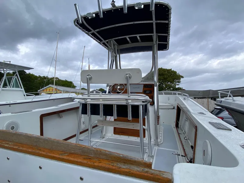 Slide: The Image of 1991 Mako 241 boat with T-top and seating, docked under cloudy skies. - 15
