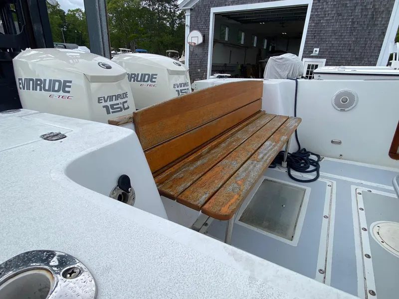 Slide: The Image of 1991 Mako 241 boat with wooden bench and Evinrude engines in a garage setting. - 17
