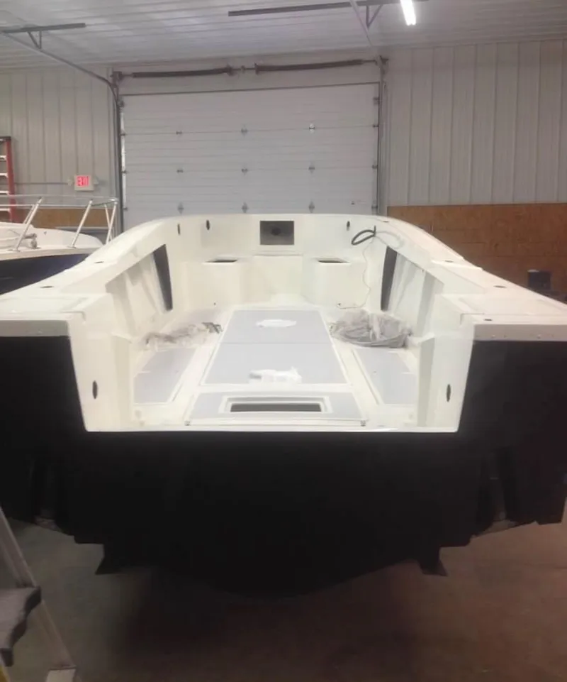 Slide: The Image of 1991 Mako 241 boat interior in a garage, showcasing spacious deck and storage areas. - 21
