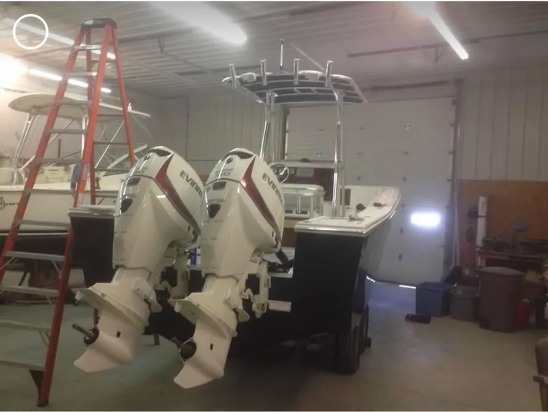 Slide: The Image of 1991 Mako 241 boat with dual Evinrude engines in a garage setting. - 24