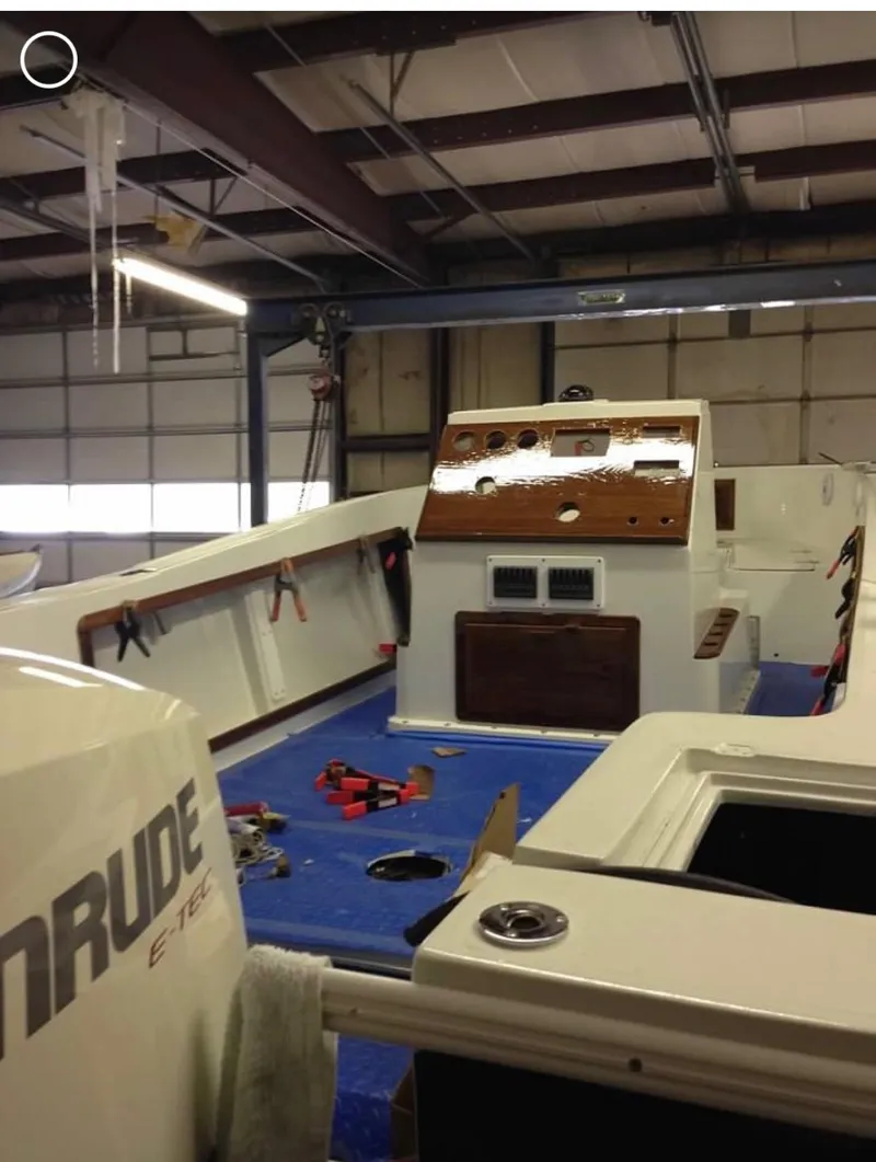 Slide: The Image of 1991 Mako 241 boat interior in a garage with Evinrude engine visible. - 28
